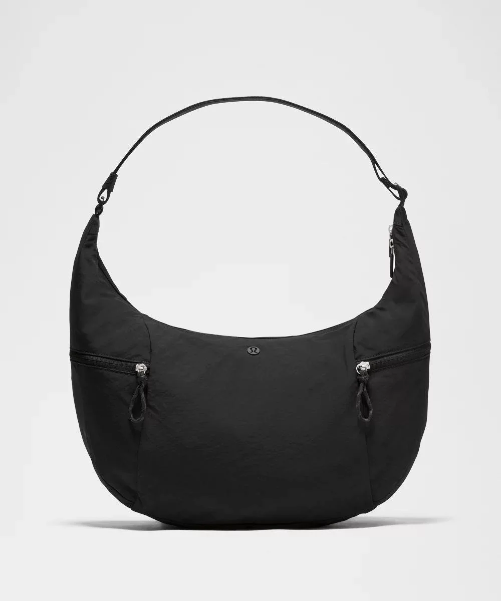 نمای روبه‌روی کیف اسلوچی اسلینگ Lululemon 13L مشکی با بدنه هلالی، بند و دو جیب زیپ‌دار بیرونی