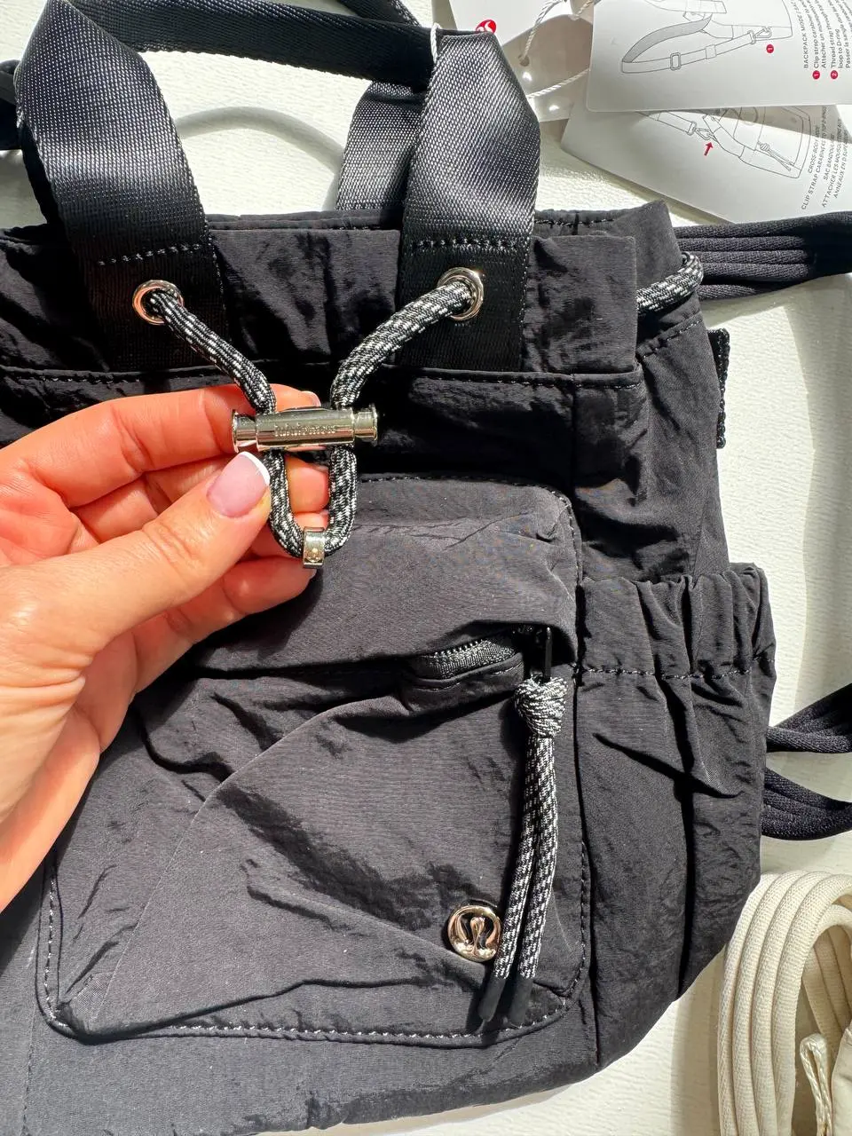 باکت بگ کانورتیبل مینی Lululemon 5L مشکی؛ جزئیات بند جمع‌شونده دهانه، قطعه فلزی جلو و جیب زیپ‌دار