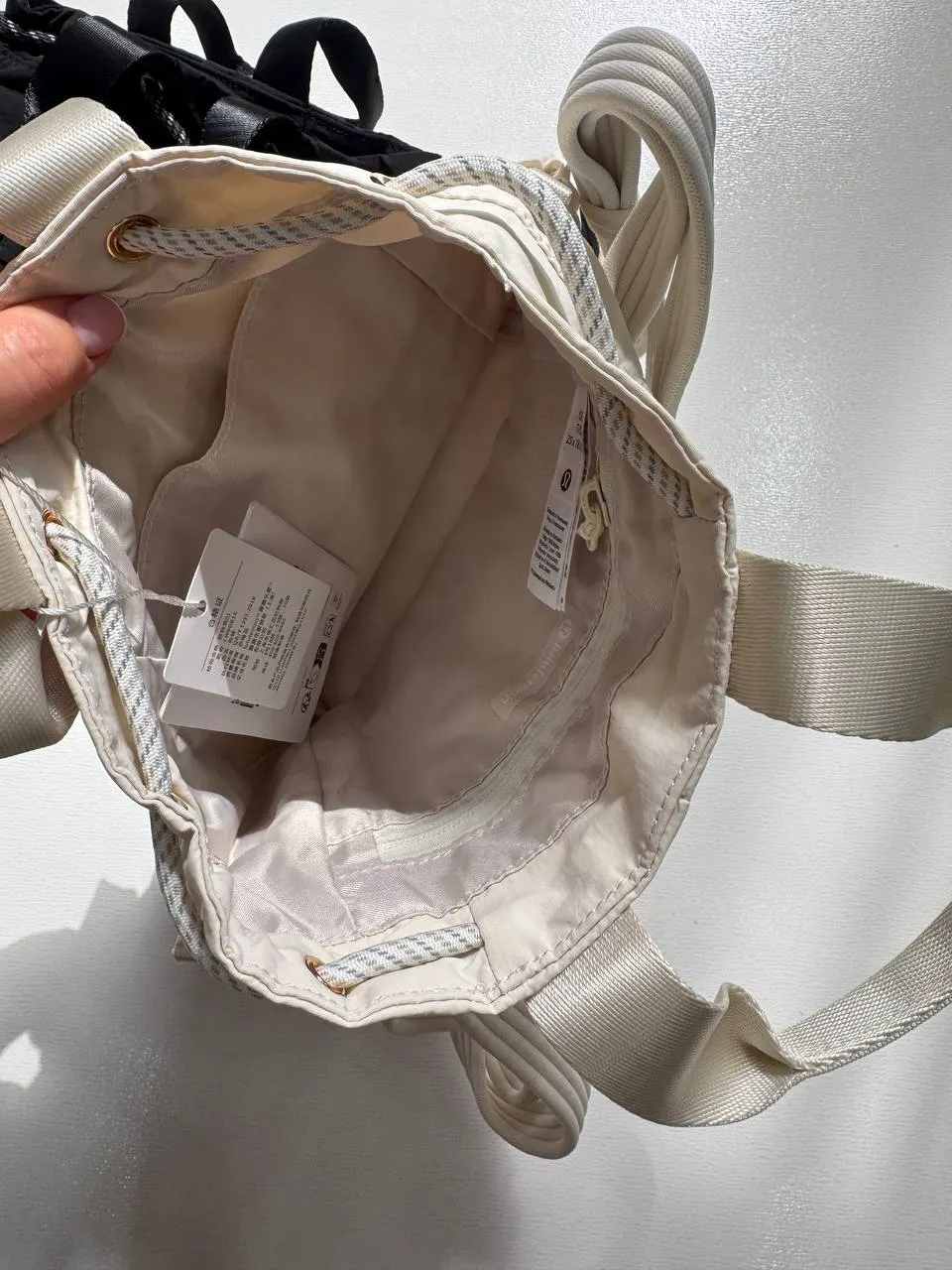 باکت بگ کانورتیبل مینی Lululemon 5L شیری؛ فضای داخلی، آستر، جیب‌ها و لیبل داخل کیف